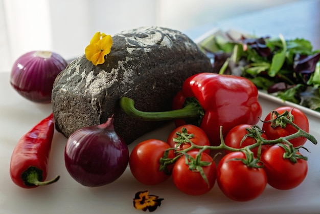 Versgebakken zelfgebakken brood met inktvisinkt en boerderij biologische groenten tomaten uien paprika Zachte selectieve focus