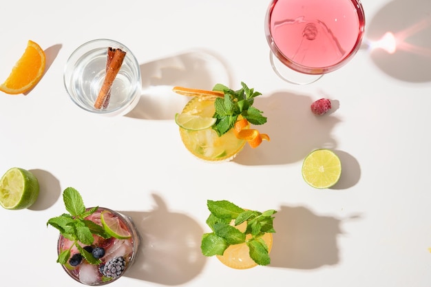 Versheid zomer cocktails limonade mai tai blackberry mojito met limoen op witte achtergrond met zonnige schaduw Zomer drank weergave van bovenaf