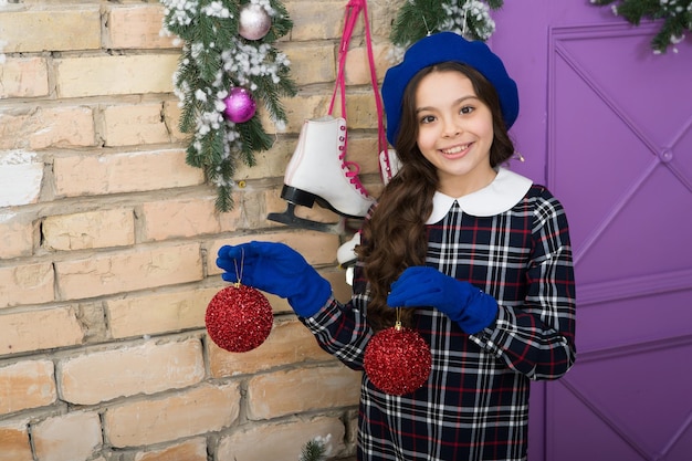 Versier voor Kerstmis met mij. Gelukkig meisje houdt kerstboomballen vast. Kleine kindglimlach met kerstversiering. Kerst inspiratie. Vrolijk kerstfeest. Oudejaarsavond. Vakantie elegantie.