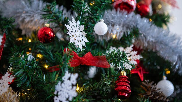 Versierd met feestelijke elementen hangen er feestelijke kerstballen op de boom.