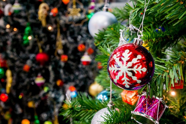 Versierde kerstboom met kleurrijke kerstbal op sprankelende bokeh licht onscherpe achtergrond