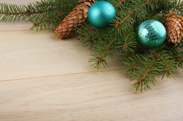 versierde kerstboomtakken op een lichte houten achtergrond met kopie ruimte