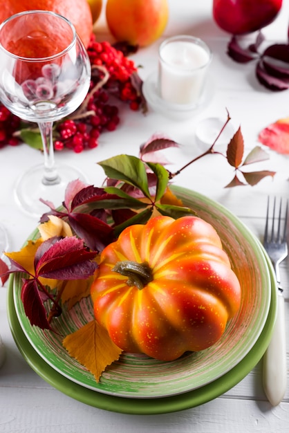 Versierde tafel met pompoen en kandelaar.