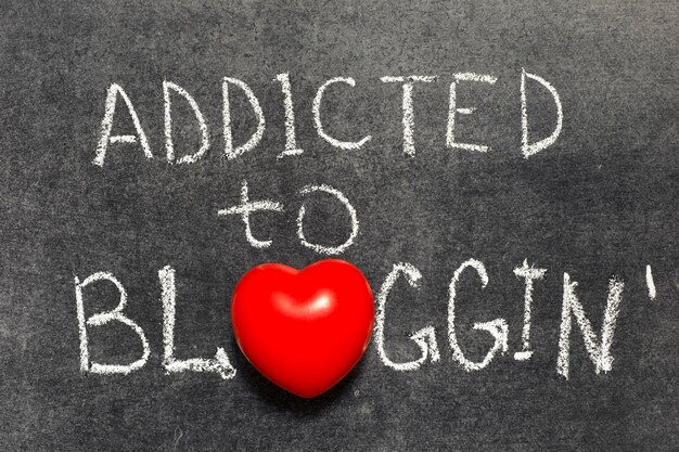 Verslaafd aan bloggen, handgeschreven op bord met hartsymbool in plaats van O