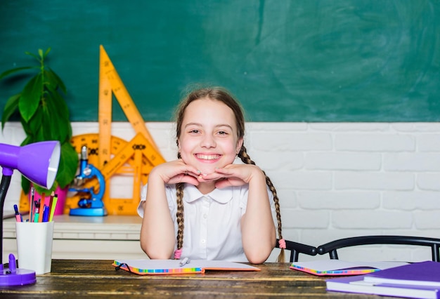 Verslaafd aan leren. Kleine jongen studie school. Kennis dag. Versnellen naar de toekomst. Thuistaak concept. Terug naar school op 1 september. Meisje schattig kind sit school klas schoolbord achtergrond.