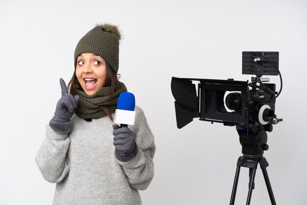 Verslaggever vrouw met een microfoon en berichtgeving over geïsoleerde witte achtergrond met de bedoeling om de oplossing te realiseren terwijl het opheffen van een vinger