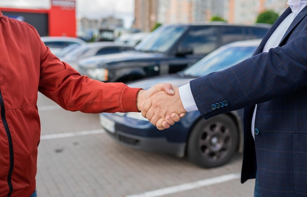 Versloeg mensen die elkaar de hand schuddenxASuccesvolle autoverkoopaankooptransactie