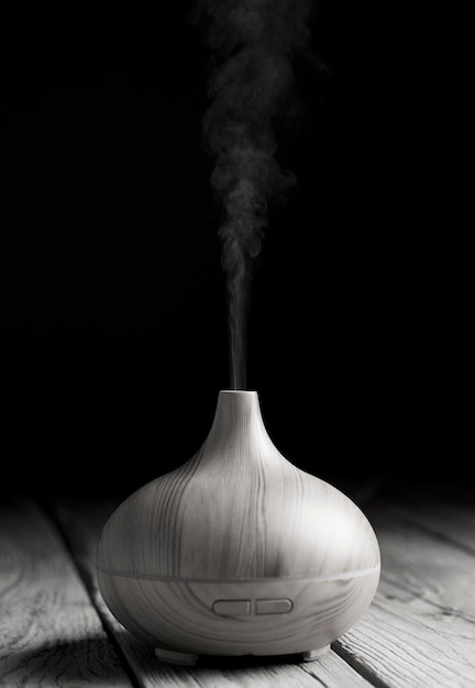 Verspreider van etherische olie van hout met elegante en zachte rondingen in zwart en wit