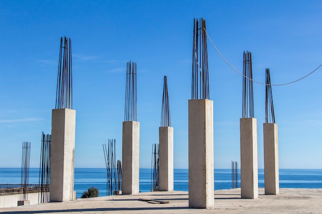 Versterkende installatie, betonnen pijlers met zee op de achtergrond, betonbekisting