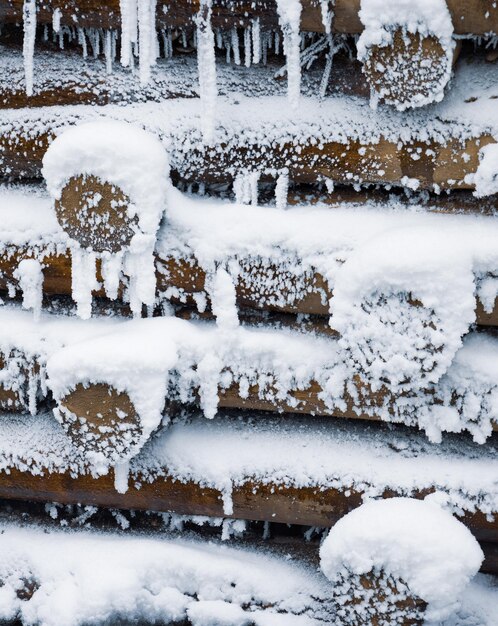 Versterking van stammen, houten muur onder sneeuw in de winter