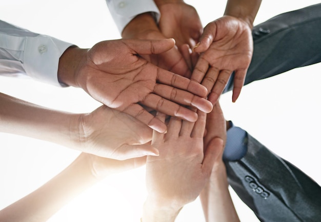 Versterkt als een team Close-up shot van een groep zakenmensen die de handen ineen slaan in eenheid