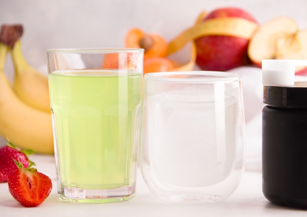 Versterkte dranken in glazen op een achtergrond van fruit. Het concept van drankjes die nuttig zijn voor sport