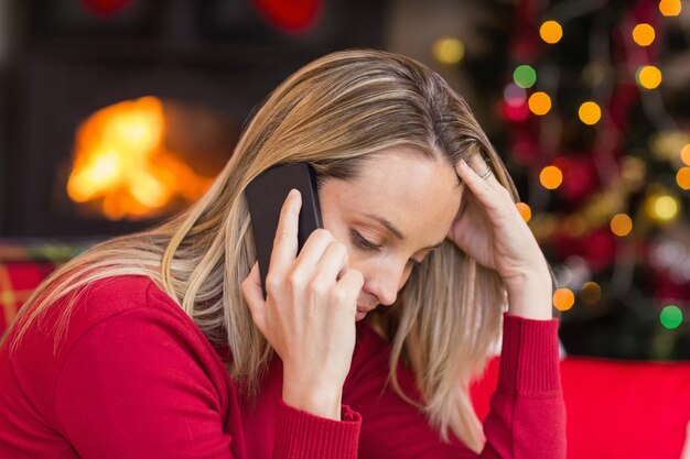 Verstoor jonge vrouw die neer terwijl het uitnodigen van telefoon kijkt