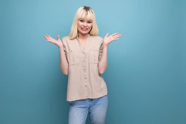 Vertederende blonde jonge blanke vrouw in vrijetijdskleding op een blauwe achtergrond