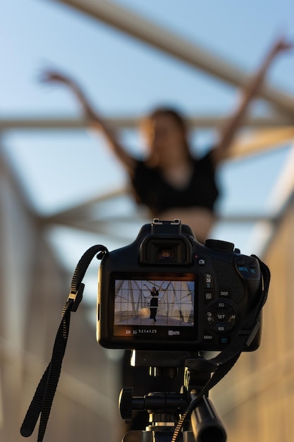 Verticaal beeld van een camera die een danseres vastlegt die danst op straat en zichzelf filmt voor sociale media en online lessen