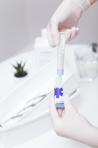 Verticaal bijgesneden shot van manicure-vulspuit met ontsmettingsmiddel voor desinfecterende vloeistof