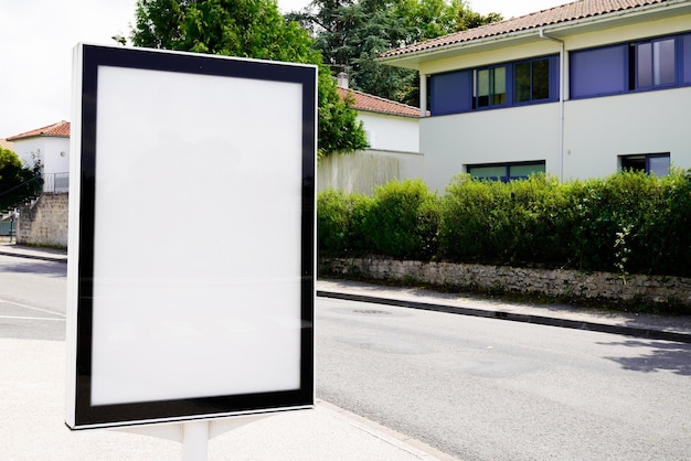 Verticaal leeg wit reclamebord in stadsstraat met stadsachtergrondgebouwen en weg