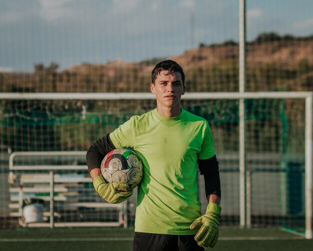 Verticaal portret van een keeper die een voetbal vasthoudt.