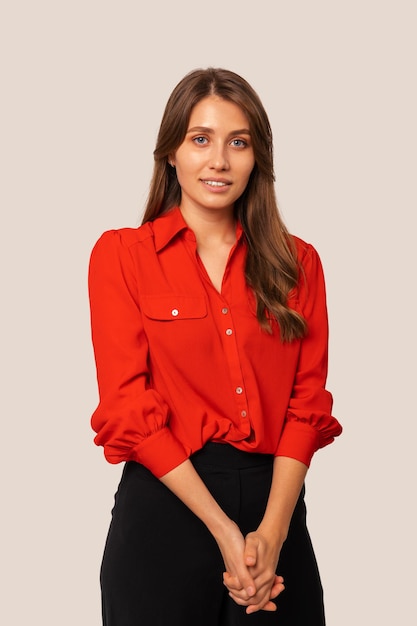 Verticaal portret van een lachende verlegen vrouw met een rood shirt in een studio