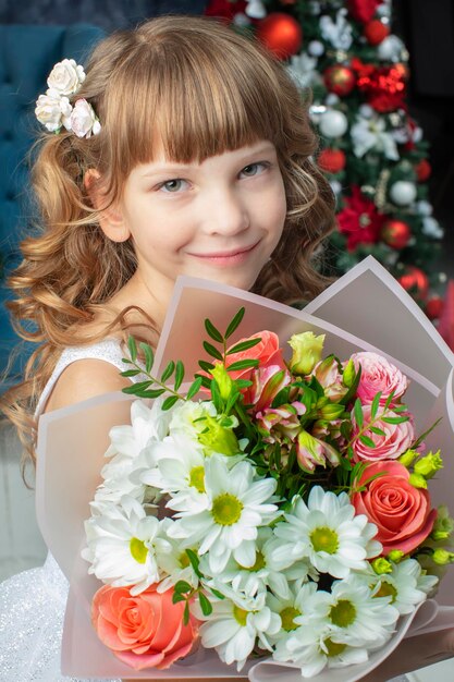 Verticaal portret van een mooi meisje met een boeket bloemen Zeven jaar oud kind