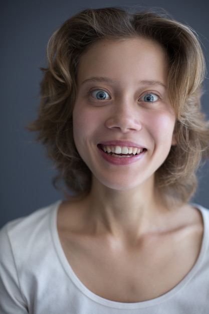 Verticaal portret van jonge verraste vrouw vreugdevol