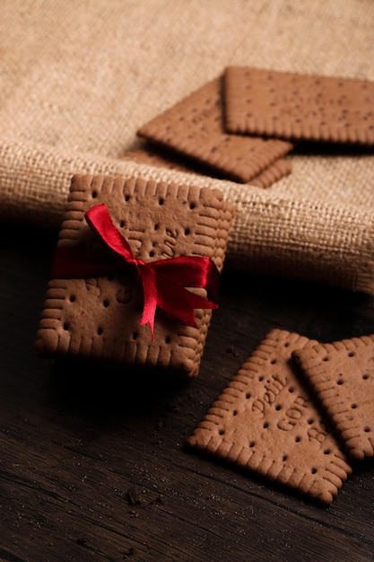 Verticaal schot van cacaokoekjes omwikkeld met rood lint op hennepdoek