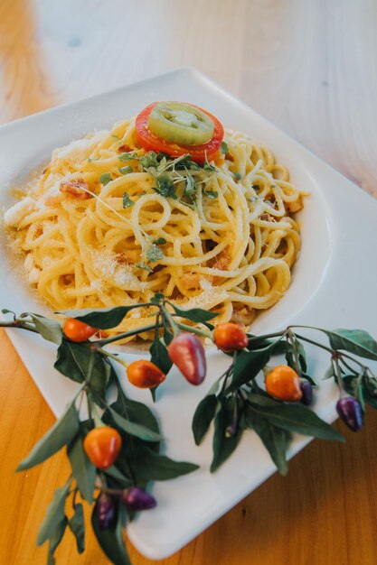 Verticaal schot van een kom heerlijke spaghetti carbonara op tafel