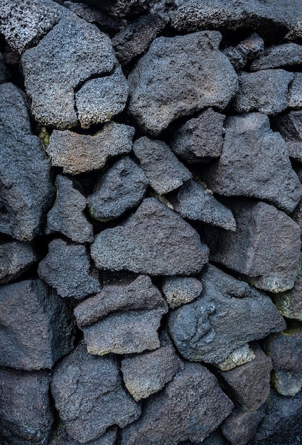 Foto verticaal schot zwarte stenen muur vulkanische steen achtergrond