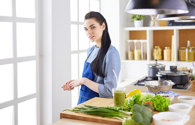 verticaal, van, jonge vrouw, staand, met, armen gekruist, tegen, keuken, background
