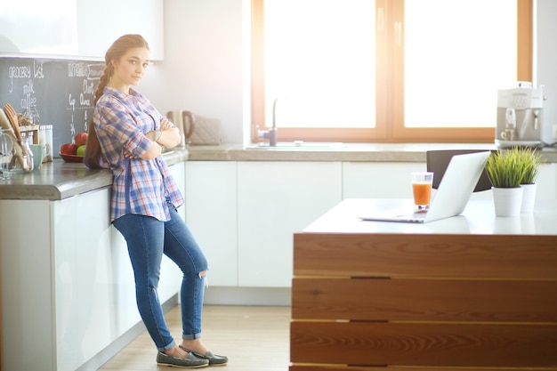 verticaal, van, jonge vrouw, staand, met, armen gekruist, tegen, keuken, background