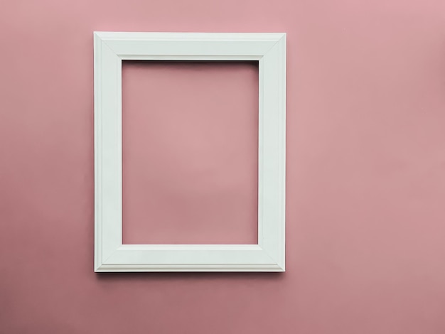 Cornice artistica verticale su sfondo rosa cipria come stampa di opere d'arte di design flatlay o album fotografico