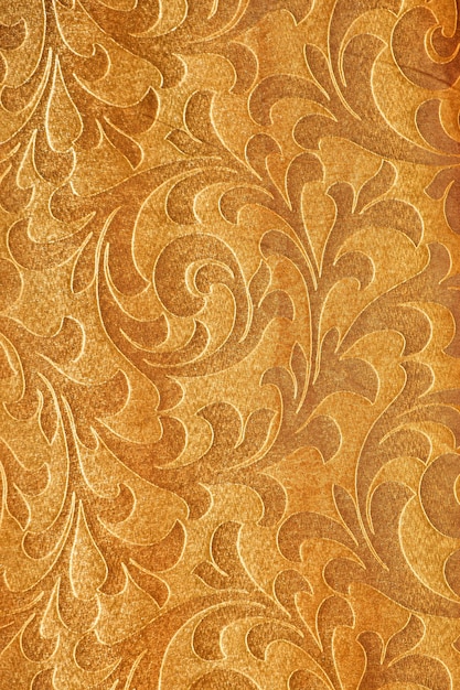 Photo vertical background of golden fabric with ornaments and folds