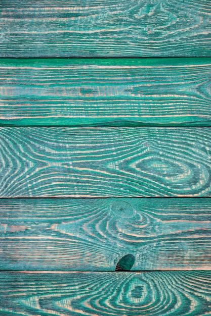 Vertical background of textured boards painted with green paint.