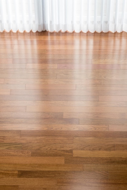 新しく設置されたブラジリアンチェリーの堅木張りの床に垂直ブラインドが影を落とします