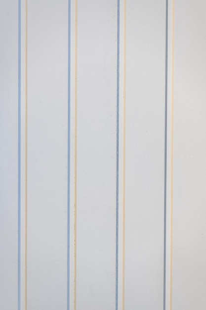 Vertical blue and beige stripe all-over wallpaper pattern on white textured background.