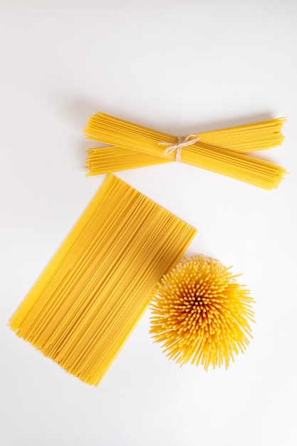 A vertical bunch and a bunch of raw spaghetti tied with string Bundle on a white background