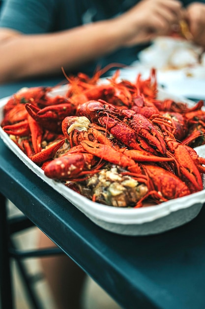 A vertical closeup of a box of fresh crawfish on the table