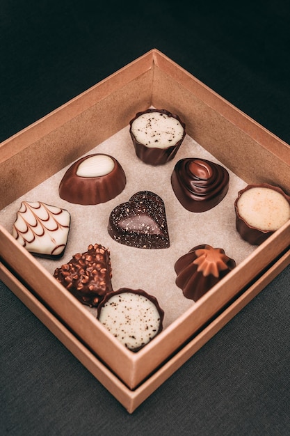 Vertical closeup of a box with chocolate on the black background