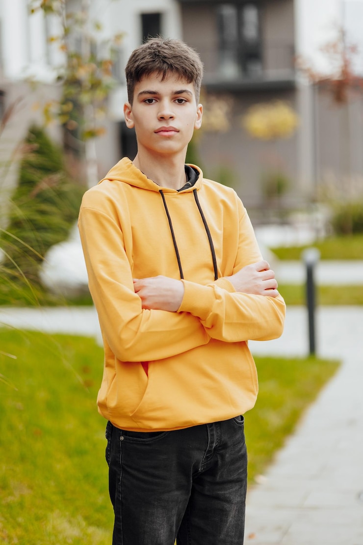 Photo vertical closeup portrait of a teenager in casual clothes happy smiling teenager in autumn park in sunlight a beautiful child looks at the camera in nature