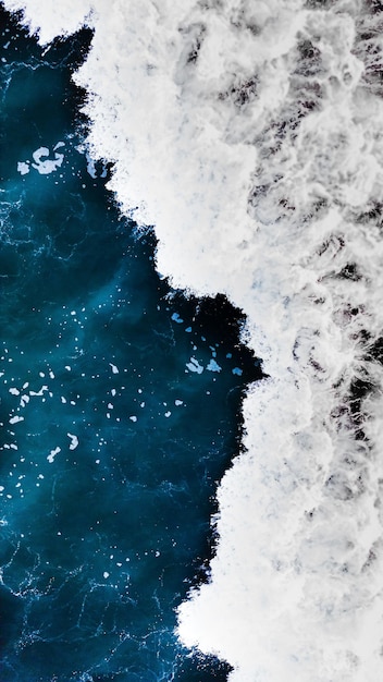 Photo vertical closeup of sea foam poster, blue waves with a long exposure effect