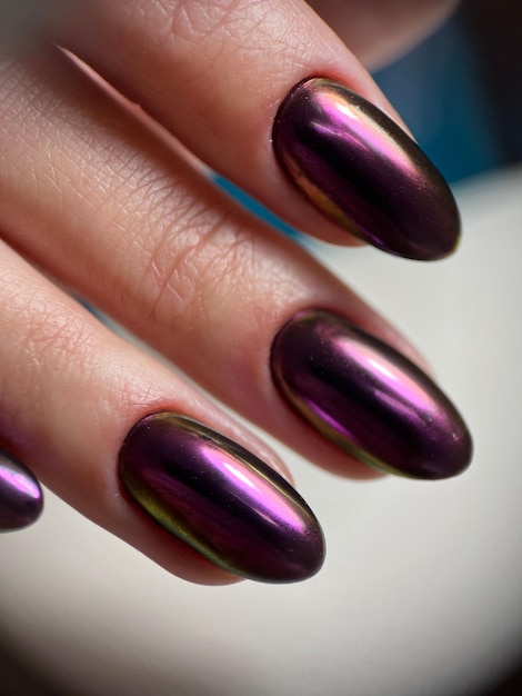 Vertical closeup shot of fingers with a trendy chrome gel nail polish.