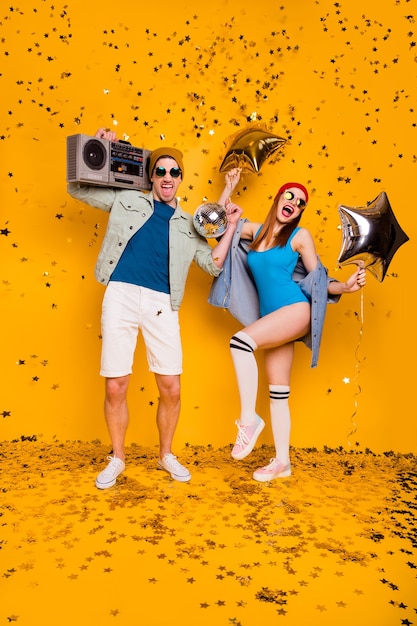 Photo vertical full length body size view of nice attractive cheerful excited glad couple dancing having fun disco leisure entertainment isolated bright vivid shine vibrant yellow color background