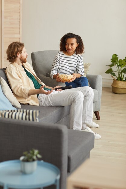 Happy Mixed Race Couple Relax On Couch In Living Room Watch Movie