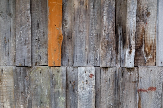 Vertical gray messy wooden planks with one brown wall suface texture and background