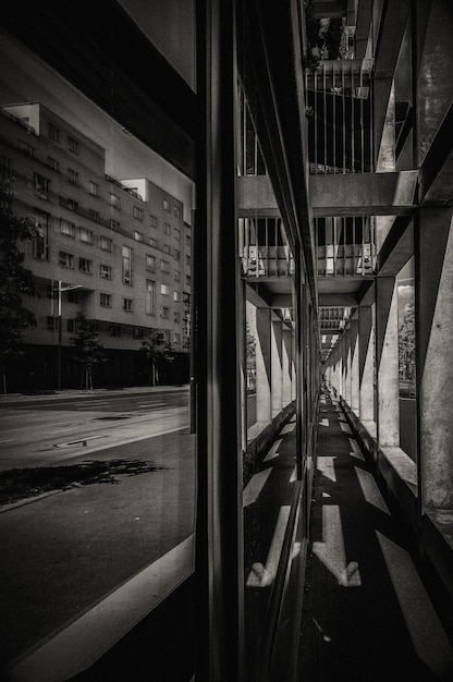 Vertical grayscale shot of the reflection of a building in the window of another