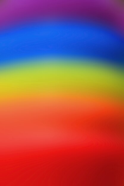 Vertical image of abstract blurred rainbow colored rubber rings stack for background