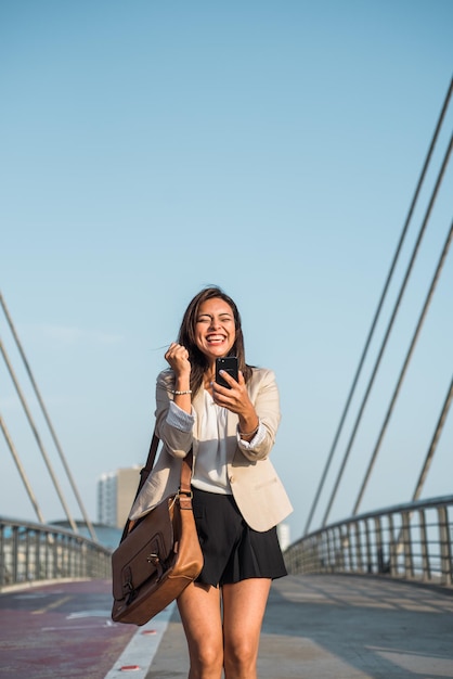 Вертикальное изображение деловой женщины, взволнованно празднующей получение приза на своем мобильном телефоне Вертикальное изображение Копировать пространство