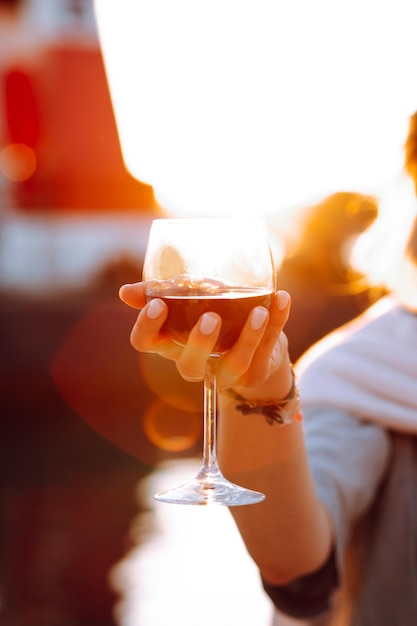 Vertical image cropped woman hand hold wineglass on vacation in travelling Remember weekend forever Female addiction