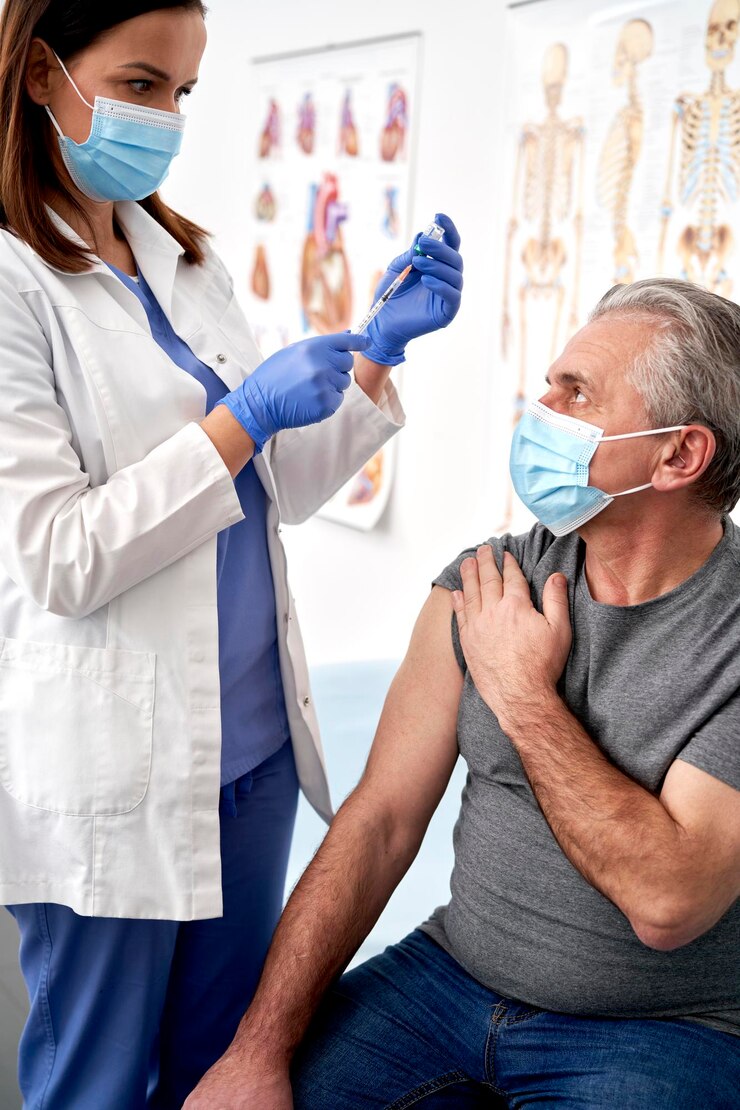 Photo vertical image of doctor preparing syringe for senior patient