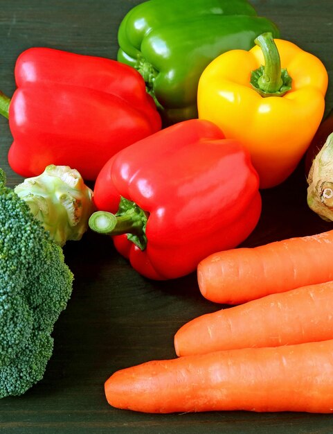 Vertical image of fresh colorful vegetables scattered on black wooden table